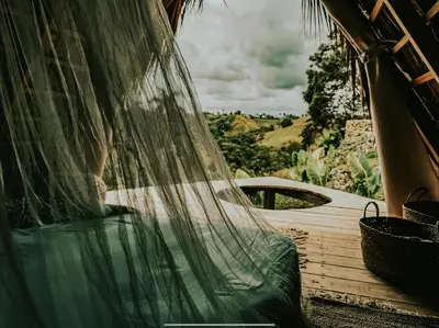 a hammock in a room with a view of a field at OYA New Earth Luxury Romantic Glamping with Private Outdoor Bath in Jamao al Norte
