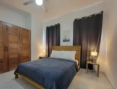 a bedroom with a bed with a blue comforter at Villa Serene Breeze Private Pool Sosua Ocean Village in Sosúa