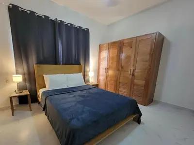 a bedroom with a bed and a wooden cabinet at Villa Serene Breeze Private Pool Sosua Ocean Village in Sosúa