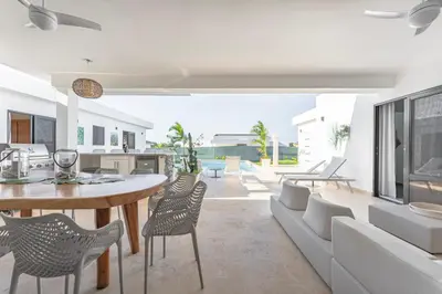 a kitchen and living room with a table and chairs at Kcasama Castle Villa 1108 in Sosúa