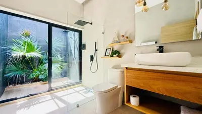 a bathroom with a toilet and a sink and a window at Villa Solana in Cabrera Dominican Republic in Cabrera
