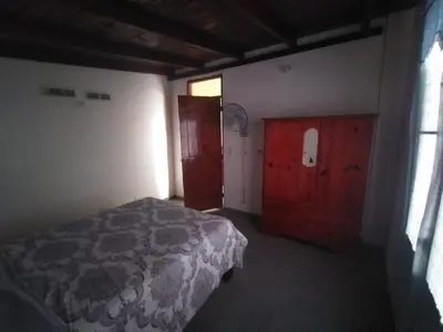 a bedroom with a bed and a wooden cabinet at Apartamentos grigri in Río San Juan