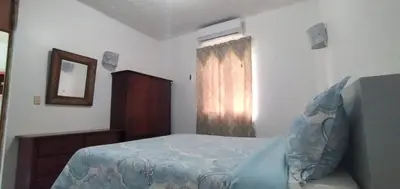 a bedroom with a bed and a mirror and a window at Apartamentos grigri in Río San Juan