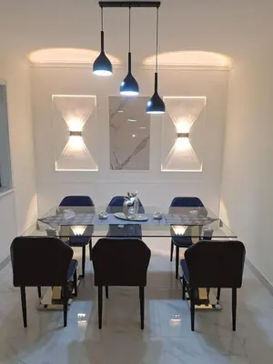 a dining room with a table and chairs and lights at Residencial cayena del este Santo Domingo este in La Grúa