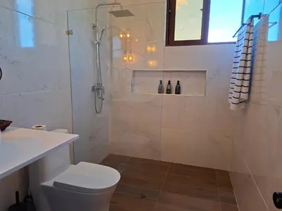 a bathroom with a shower and a toilet and a sink at Hermosa villa familiar cucu's home beach in Río San Juan