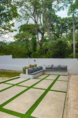 a couch sitting on a patio with grass at Villa my place in Bonao