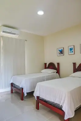 a room with two beds and a air conditioner at Villa my place in Bonao