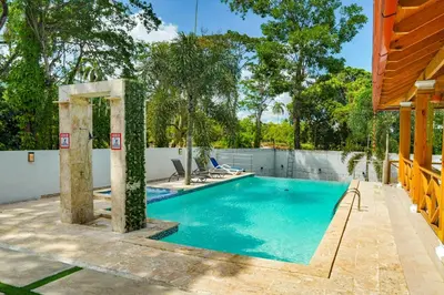 a swimming pool in a backyard with a fence and trees at Villa my place in Bonao
