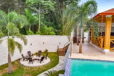 a backyard with a pool and patio furniture and a house at Villa my place in Bonao