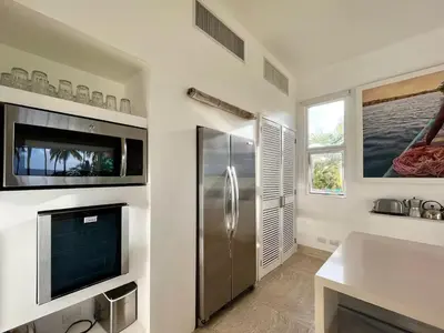 a kitchen with a stainless steel refrigerator and a sink at Playa Bonita Modern Beachfront Penthouse - 3BR in Las Terrenas