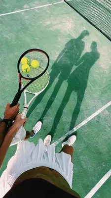 a person holding a tennis racket and balls on a tennis court at Playa Bonita Modern Beachfront Penthouse - 3BR in Las Terrenas