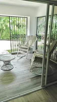 a screened in porch with chairs and a table at Casa Valentina in Río San Juan