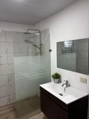 a bathroom with a sink and a shower with a mirror at Casa Valentina in Río San Juan