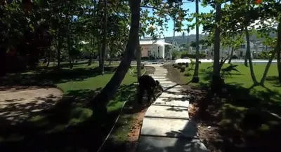 a sidewalk in a park with trees and a building at Charming Villa GUGI #80 in Palmeras de Coson, Las Terrenas in Las Terrenas
