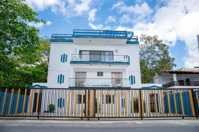 a white building with a fence in front of it at beachfront apartment in La Puntica de Juan Dolio
