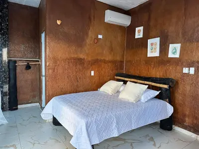 a bedroom with a bed with a wooden wall at Guest-House Caracol 1- 2 Pax, vista al mar in Las Galeras