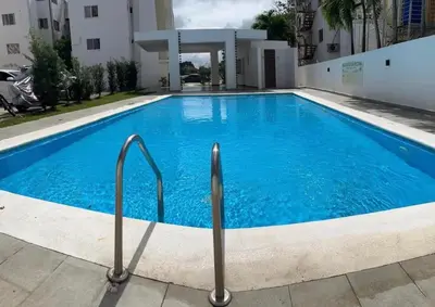 a swimming pool with blue water in front of a building at Cozy apartment in Licey al Medio in Licey al Medio
