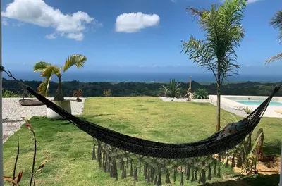 a hammock on top of a field with a pool at Villa Brisa del Caribe in Las Terrenas