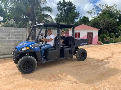 a man and a boy in a golf cart at Villa Brisa del Caribe in Las Terrenas