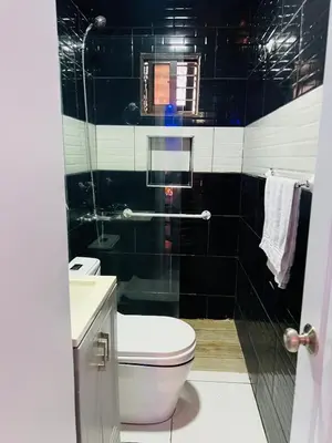 a black and white bathroom with a toilet and a sink at Style and comfort in downtown Santiago in Santiago de los Caballeros