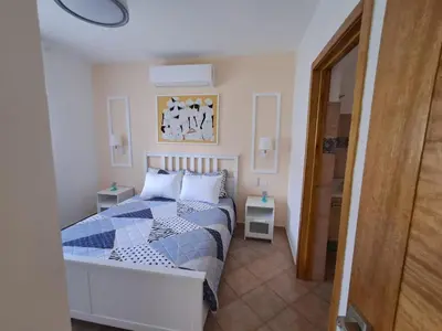 a bedroom with a bed with a blue and white comforter at Apartamentos Cayuco 28 in La Laguna