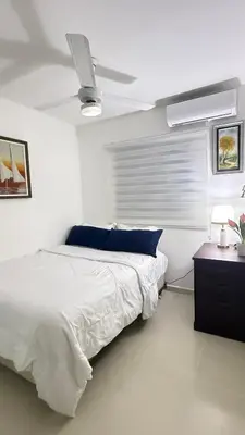 a white bedroom with a bed and a ceiling fan at Apartamento en Santo Domingo Pablo mella morales in Hato Nuevo