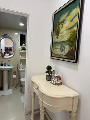 a bathroom with a table with a painting on the wall at Apartamento en Santo Domingo Pablo mella morales in Hato Nuevo