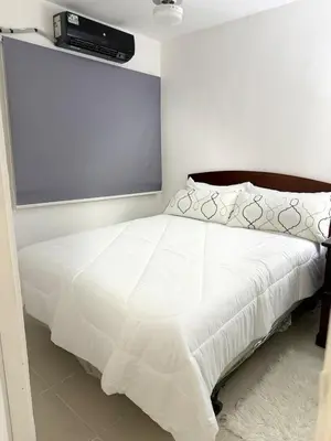 a bedroom with a white bed with a projector on the wall at Apartamento en Santo Domingo Pablo mella morales in Hato Nuevo