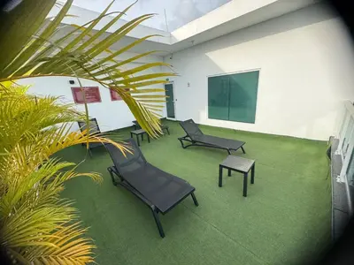 a room with chairs and a table and a screen at Chic City Apartment Walk to Everything! in Santo Domingo