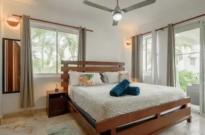 a bedroom with a bed and a large window at Playa Privada | Terraza & Piscina • WiFi Rápido in Punta Cana