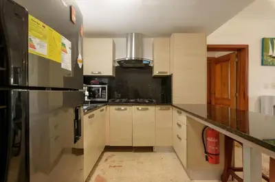 a kitchen with a stainless steel refrigerator and white cabinets at Playa Privada | Terraza & Piscina • WiFi Rápido in Punta Cana