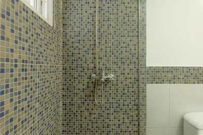 a bathroom with a shower with blue tiles at Playa Privada | Terraza & Piscina • WiFi Rápido in Punta Cana
