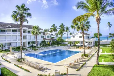 an aerial view of a resort with a pool and palm trees at Beachfront apartment in Las Terrenas