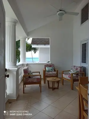 a living room with chairs and a table at Beachfront apartment in Las Terrenas