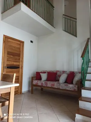 a living room with a couch with red and white pillows at Beachfront apartment in Las Terrenas