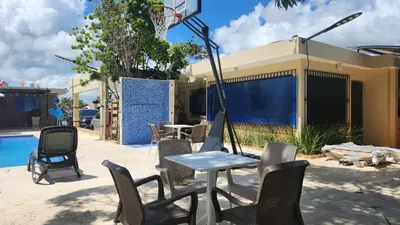 a patio with a table and chairs and a basketball hoop at Casa club by mama nelsy in Santa Cruz de El Seibo