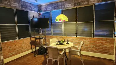 a dining room with a table and chairs and a tv at Casa club by mama nelsy in Santa Cruz de El Seibo