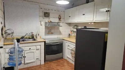 a kitchen with white cabinets and a black refrigerator at Casa club by mama nelsy in Santa Cruz de El Seibo