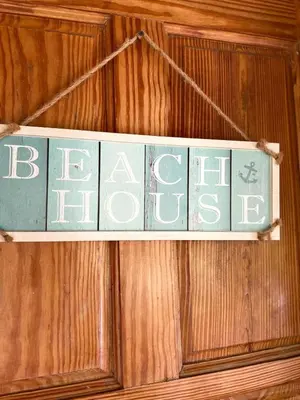 a sign that says beer hanging on a wooden wall at 21 Palms in Las Galeras