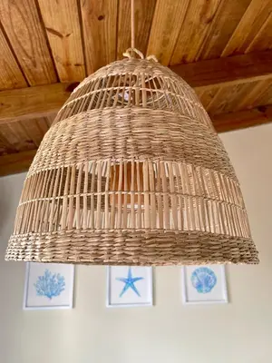 a large wicker chandelier hanging from a ceiling at 21 Palms in Las Galeras