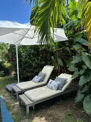 a group of lounge chairs with an umbrella at 21 Palms in Las Galeras