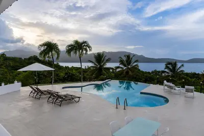 a pool with chairs and tables and a view of the ocean at Villa Playa Colorada Eco-Luxury Beachfront Retreat in La Colmena