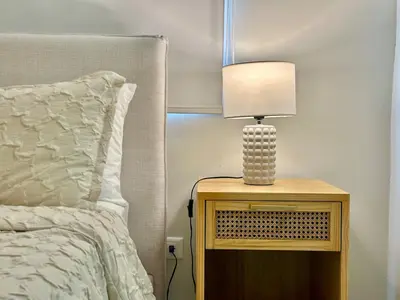 a lamp on a night stand next to a bed at Paradises Room in Boca Chica