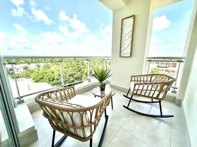 two chairs and a table in a room with a large window at Paradises Room in Boca Chica
