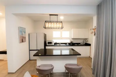 a kitchen with a black counter and a refrigerator at TRACADERO Ocean Pearl Suite in La Laguna