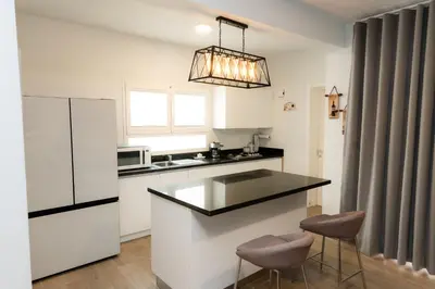 a kitchen with a counter and two stools at TRACADERO Ocean Pearl Suite in La Laguna