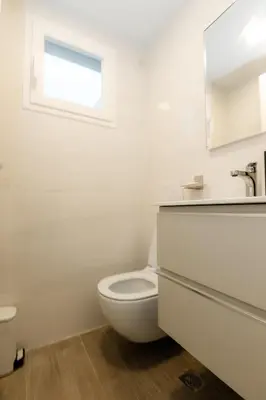 a white bathroom with a toilet and a window at TRACADERO Ocean Pearl Suite in La Laguna
