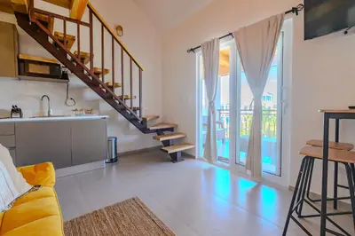 a kitchen and a living room with a spiral staircase at Esprit Caribbean Bayahibe by Caribbean Paradise Rentals in Bayahibe