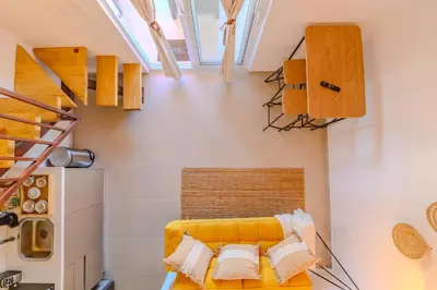 a room with a yellow couch with pillows at Esprit Caribbean Bayahibe by Caribbean Paradise Rentals in Bayahibe