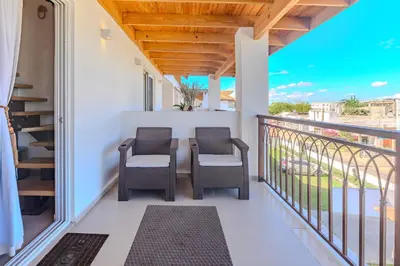 a balcony with two chairs and a table at Esprit Caribbean Bayahibe by Caribbean Paradise Rentals in Bayahibe